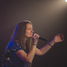a woman holding a microphone on stage 