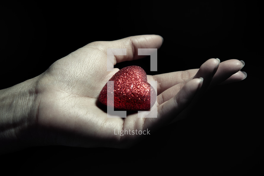 a red heart in a cupped hand 