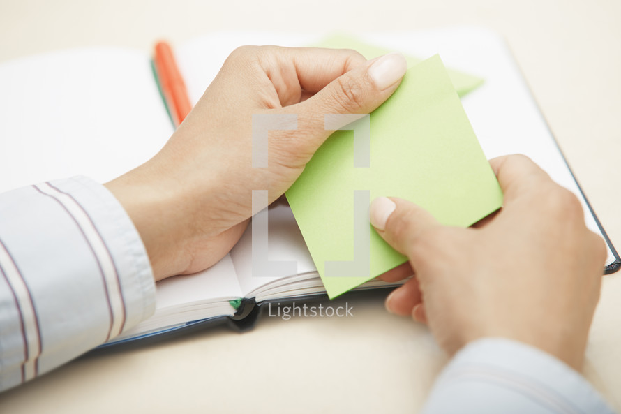 woman holding a blank sticky note 
