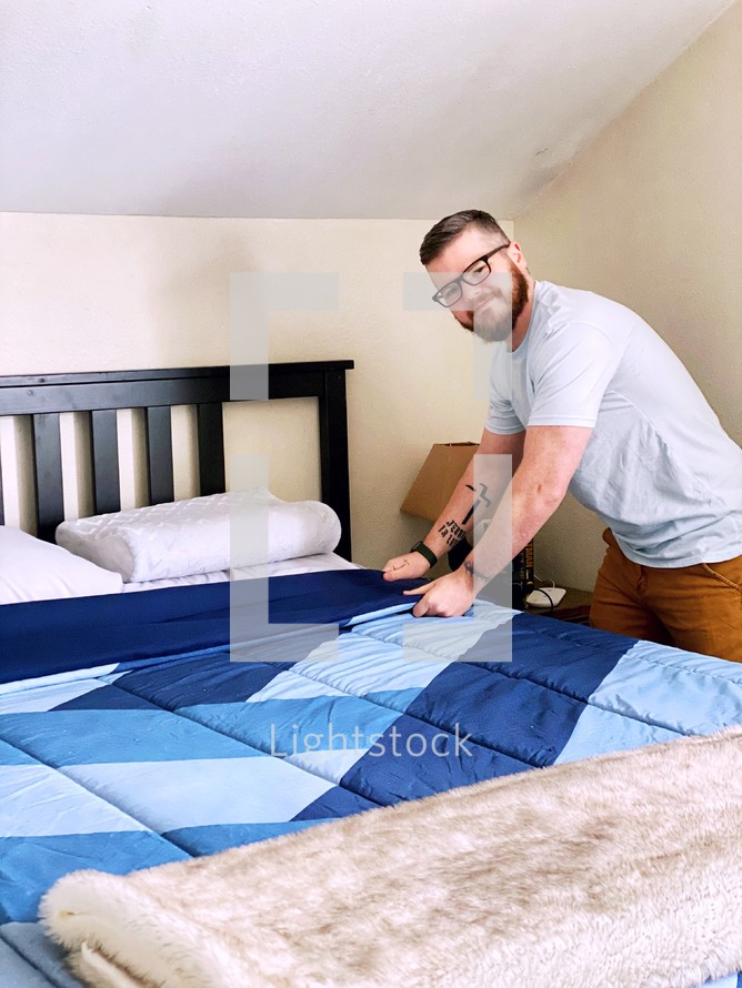 a man making the bed 