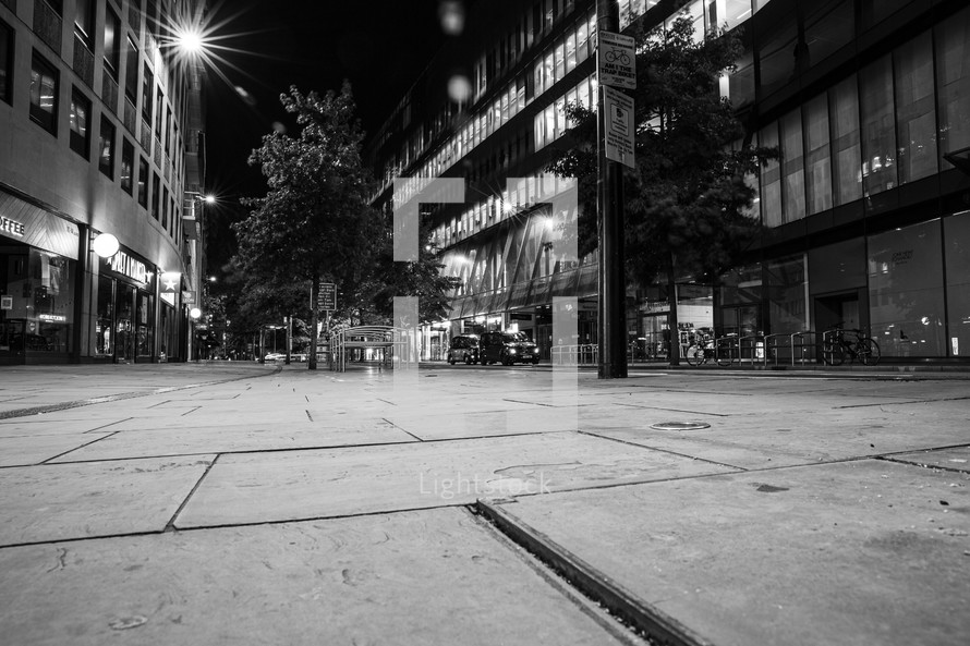 empty sidewalk in a city at night 
