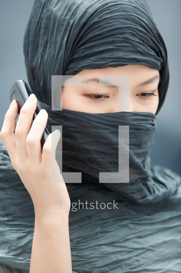 veiled woman talking in a cellphone 