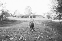 a toddler girl walking in the grass 