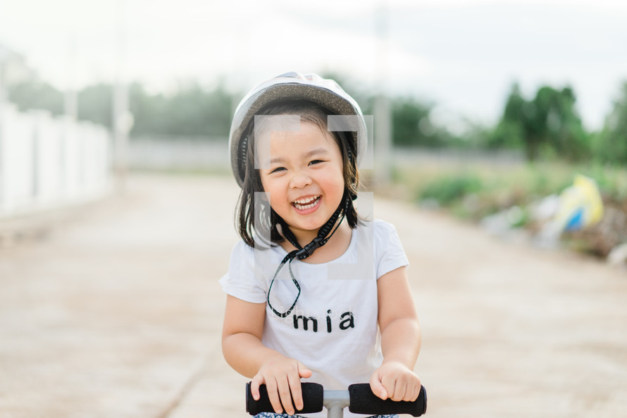 a little girl on a scooter 