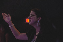 a woman with hands raised during a worship service 