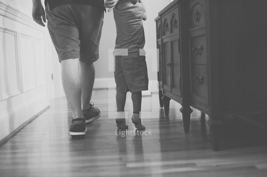 father and toddler son on a wood floor 