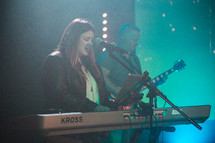 woman singing and playing the keyboard during a worship service 