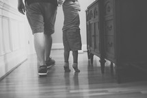 father and toddler son on a wood floor 