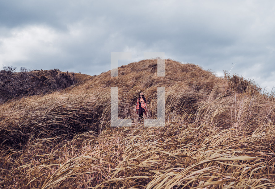 portrait of woman in a field of tall brown grasses 