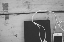 earbuds on an iPhone and Bible 