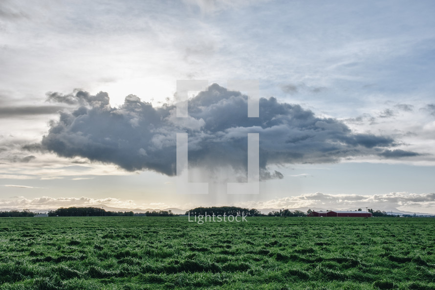 rain clouds over a green field 