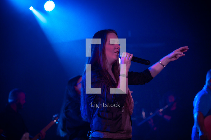 female worship leader singing on stage 