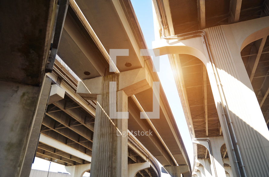 Underneath a highway bridge with sunlight