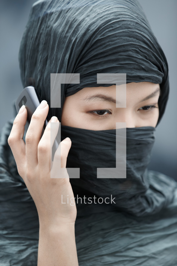 a veiled woman talking on a phone 
