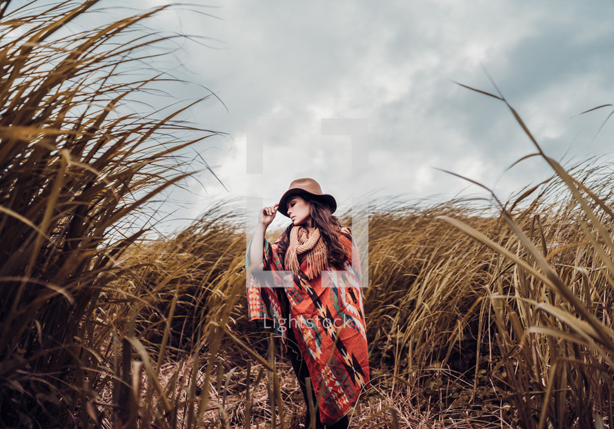 a woman in a field of tall brown grasses 