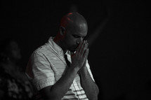 a man praying during a worship service 