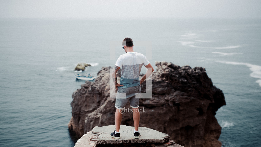 a man standing on a rock jetty 