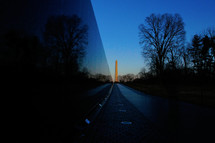 The Vietnam Veterans Memorial wall. The Washington monument can be seen in the background.