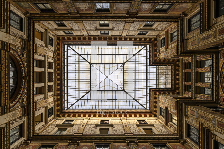 looking up through sky lights in an ornate building 