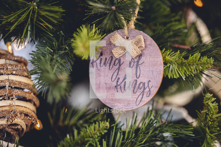 Wooden ornament with the word "king of kings" on a Christmas tree 