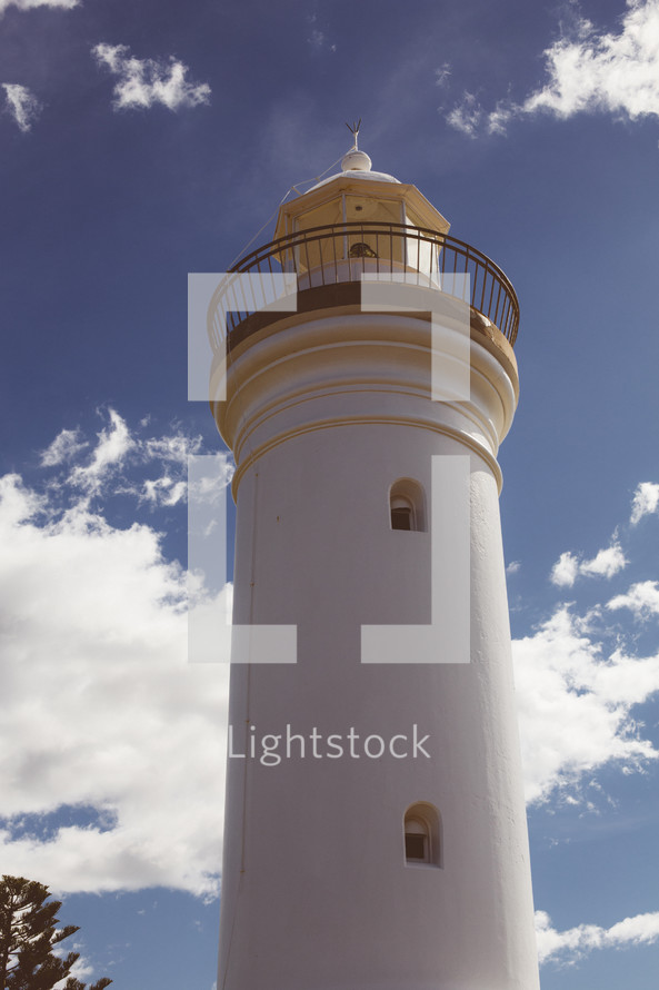 Lighthouse with a cloudy sky.