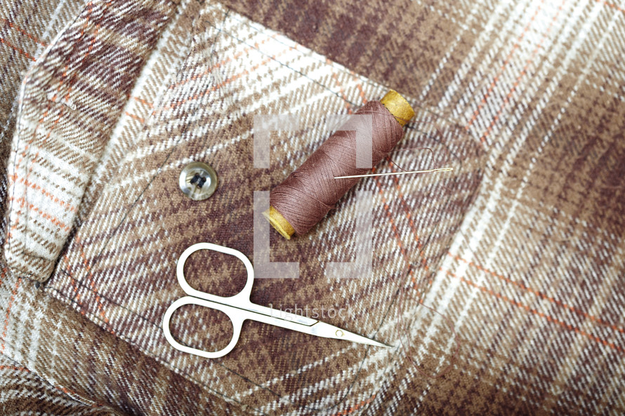 scissors and needle and thread on a pocket 