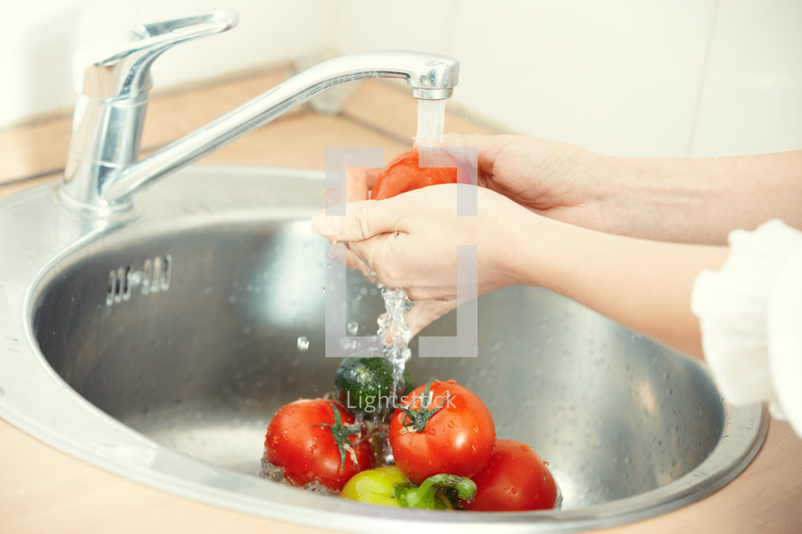 washing vegetables in a sink 