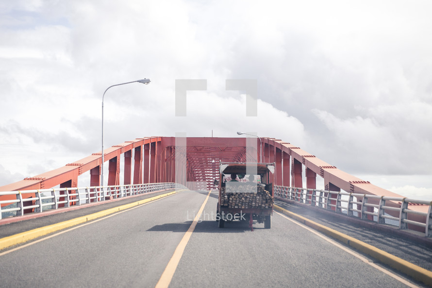 truck carrying boards crossing a bridge 