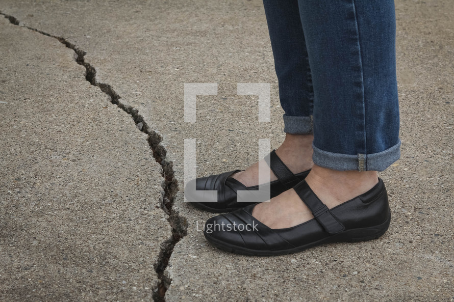 woman standing beside a crack 