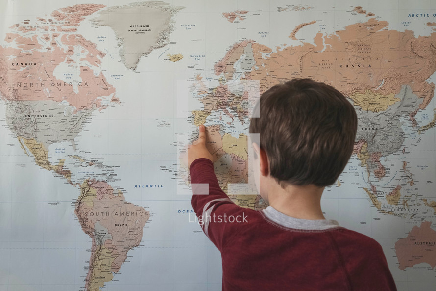 world map and child pointing to it 