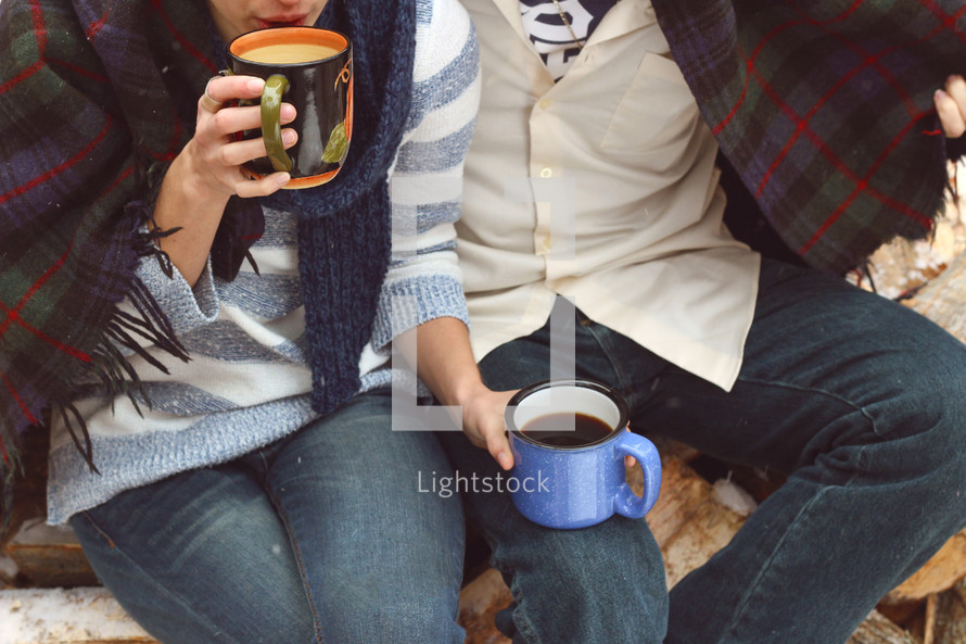 a couple snuggled up drinking coffee 