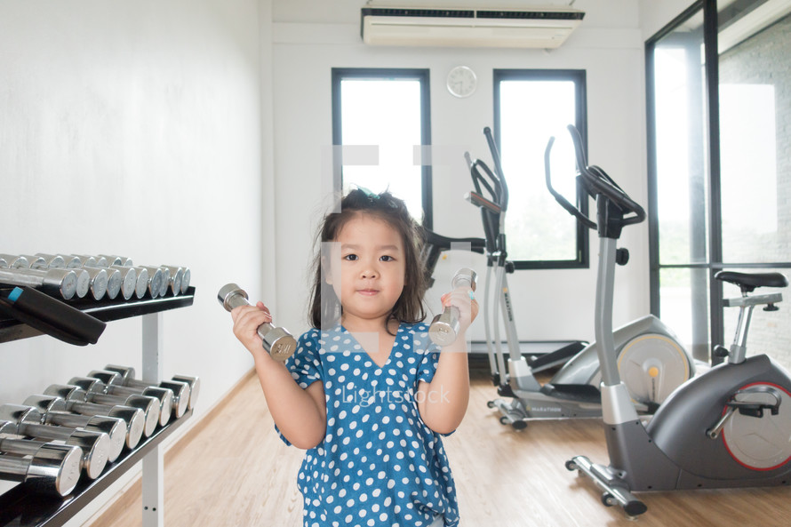 child lifting weights at the gym