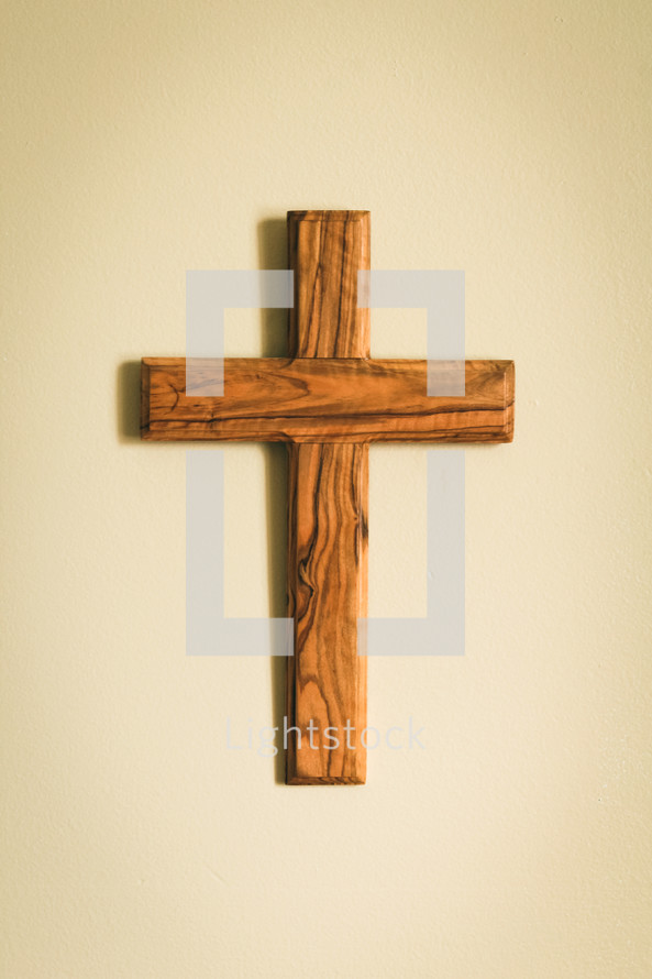 simple wooden cross hanging on a wall 