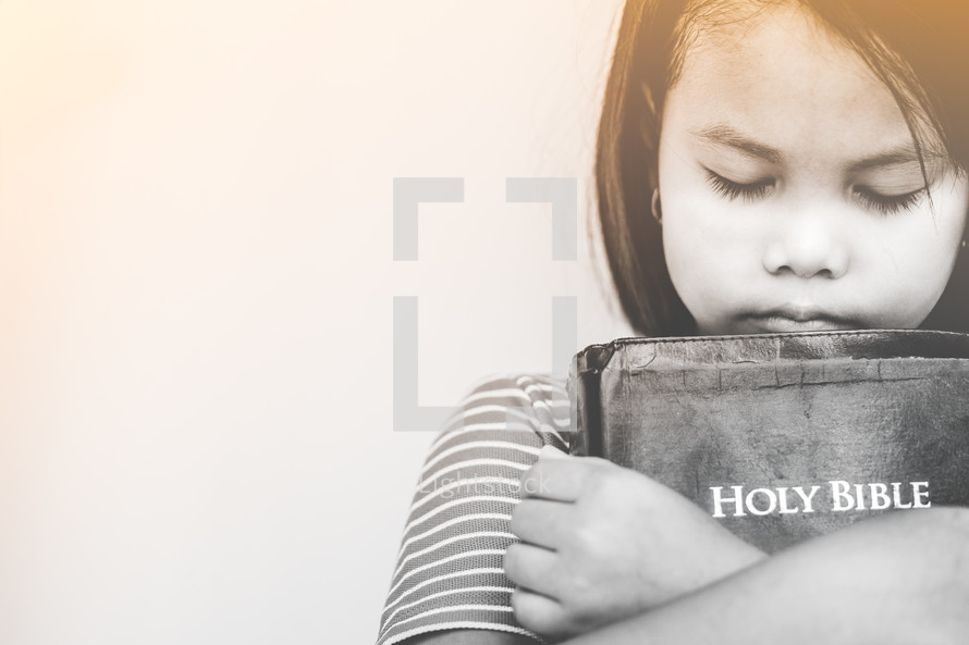 girl hugging a Bible 