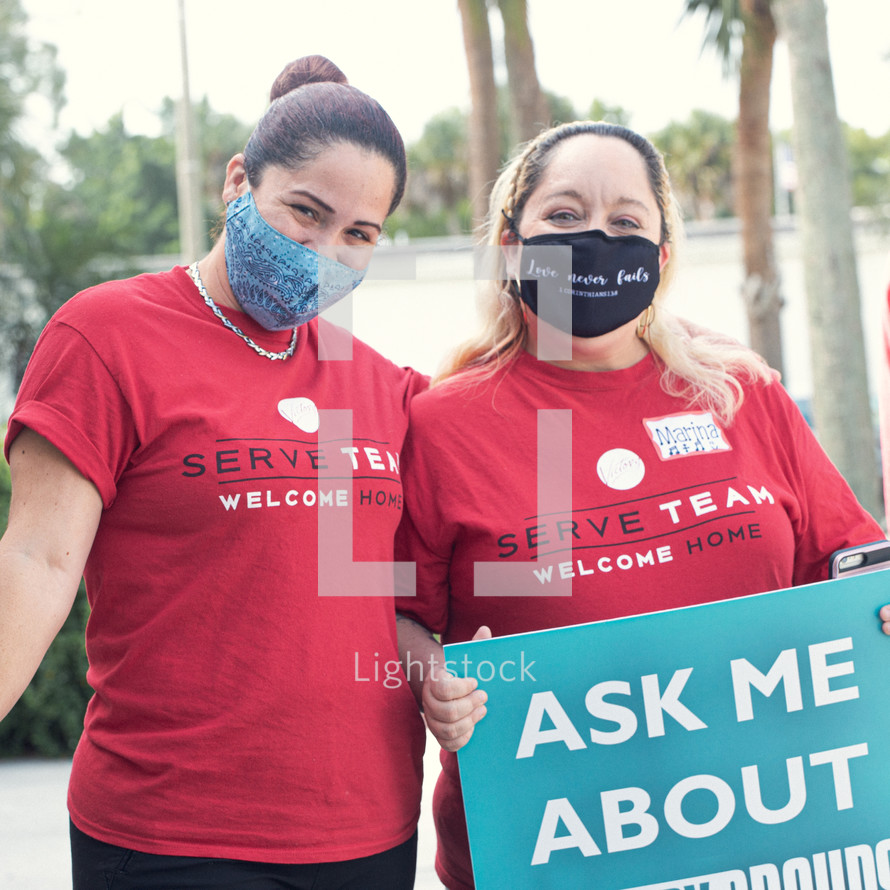 women standing outside of a church wearing face masks 