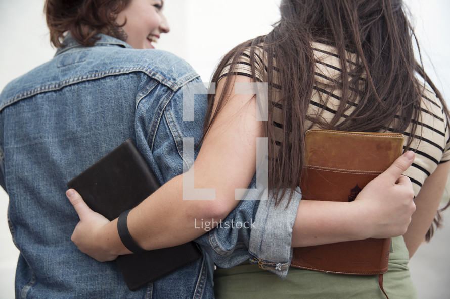 young women hugging holding Bibles 