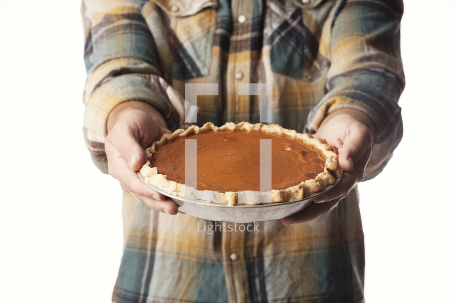 man holding a pumpkin pie 