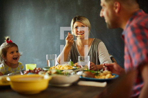 A family eating a meal together — Photo — Lightstock