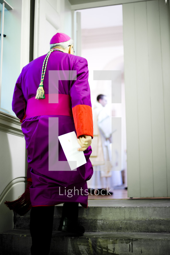 Priest walking up steps.