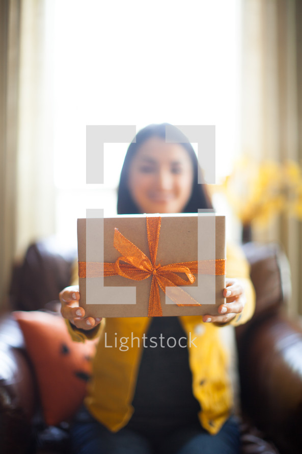 a woman holding a wrapped present 