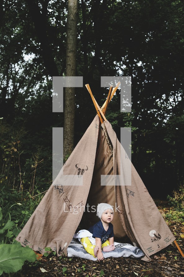 an infant boy in a teepee 