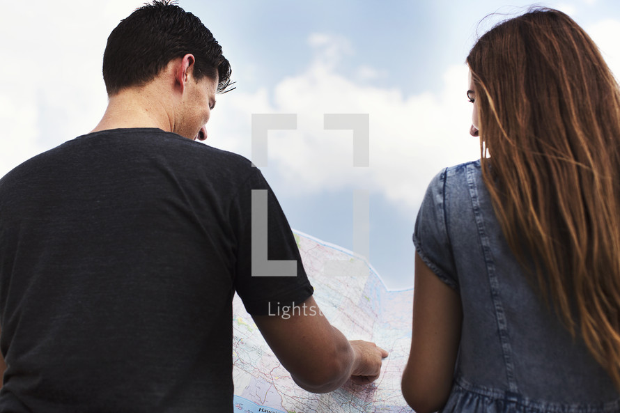 man and woman pointing to a map 