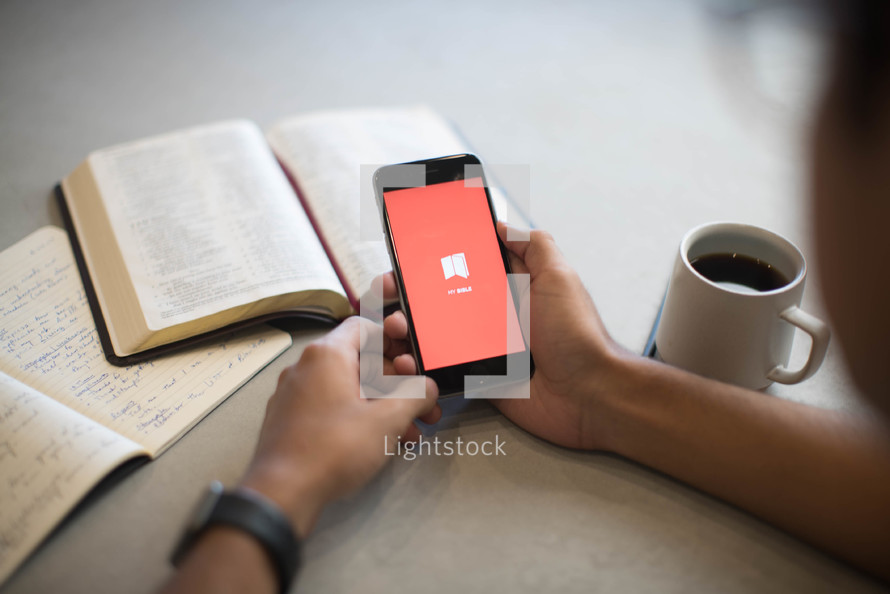 a man opening a Bible app on his phone 