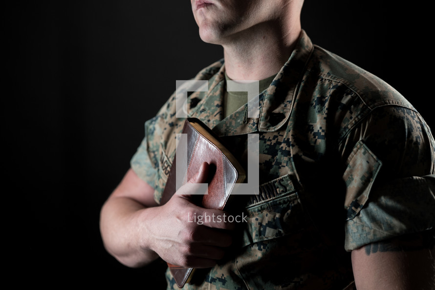 a marine holding a Bible against his chest 