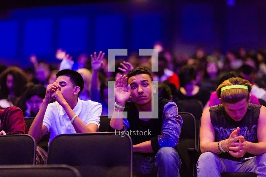 youth sitting in a packed auditorium 