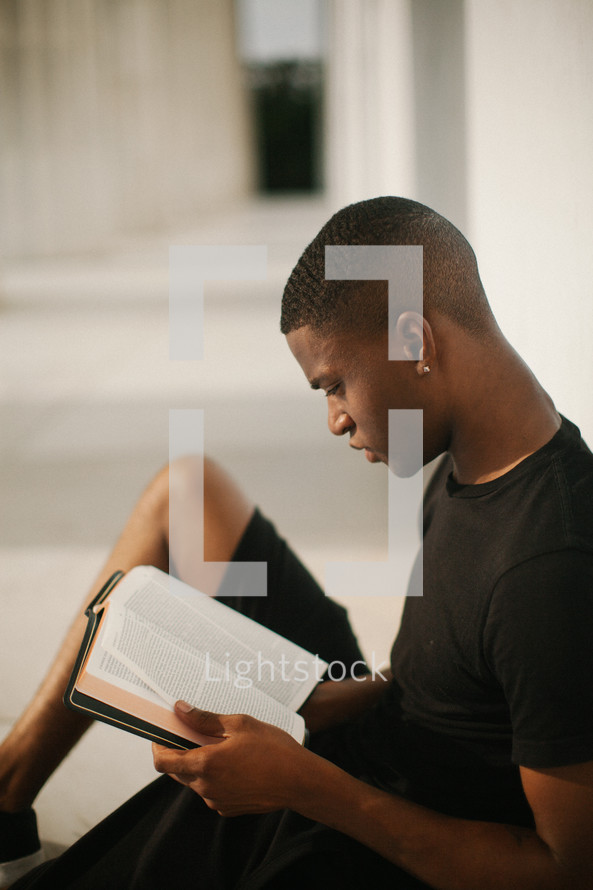 African American man sitting reading a Bible 