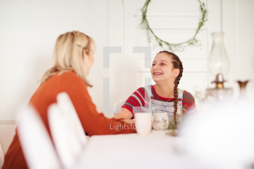 mother and daughter talking at the kitchen table 