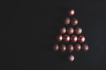 chocolate candies in a Christmas tree shape on a black background 