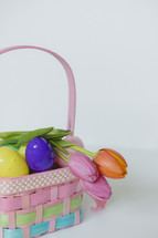 plastic Easter eggs and tulips in a basket 