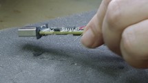 Manual soldering of electronic components on a PCB board, close up
